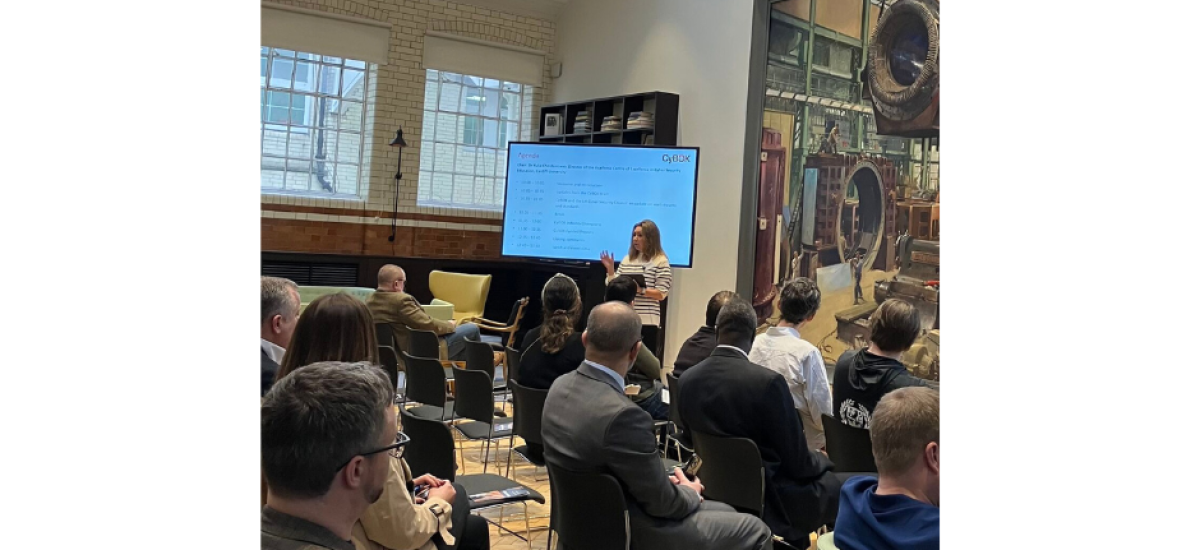 sean cybok blog Picture of CyBOK event, multiple people seated whilst watching a woman present